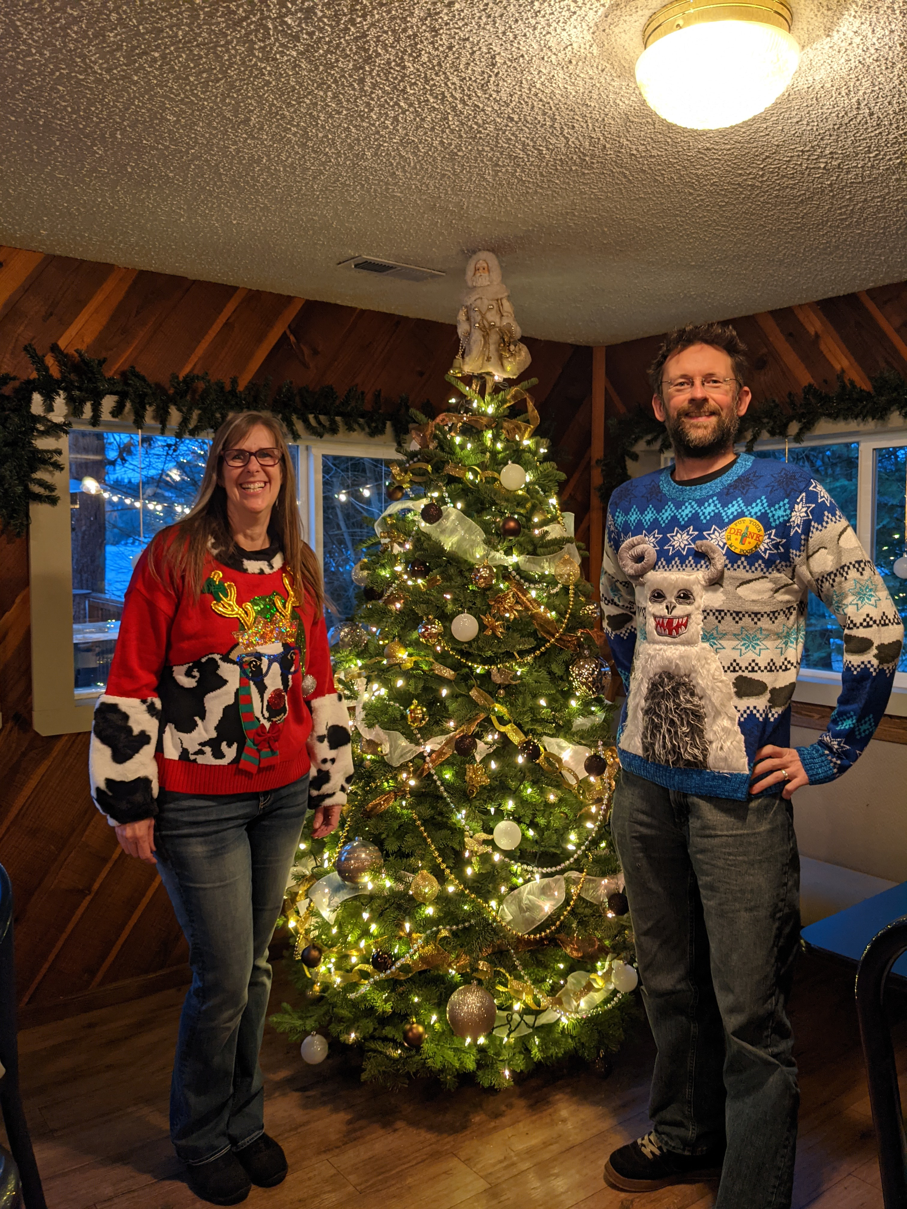 Christmas 2021 by the tree in our ugly sweaters
