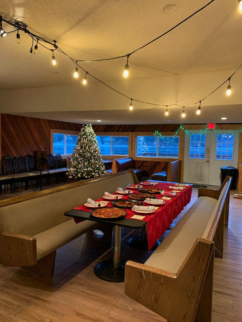 Table set for Christmas dinner with  pizza and Christmas crackers in the Sedlmayer's Restaurant